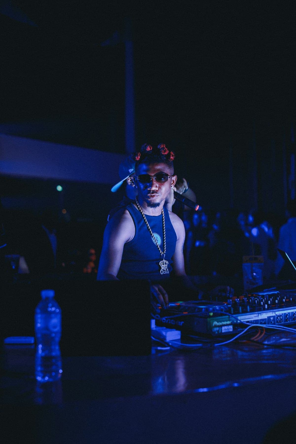 A DJ at the decks under blue light